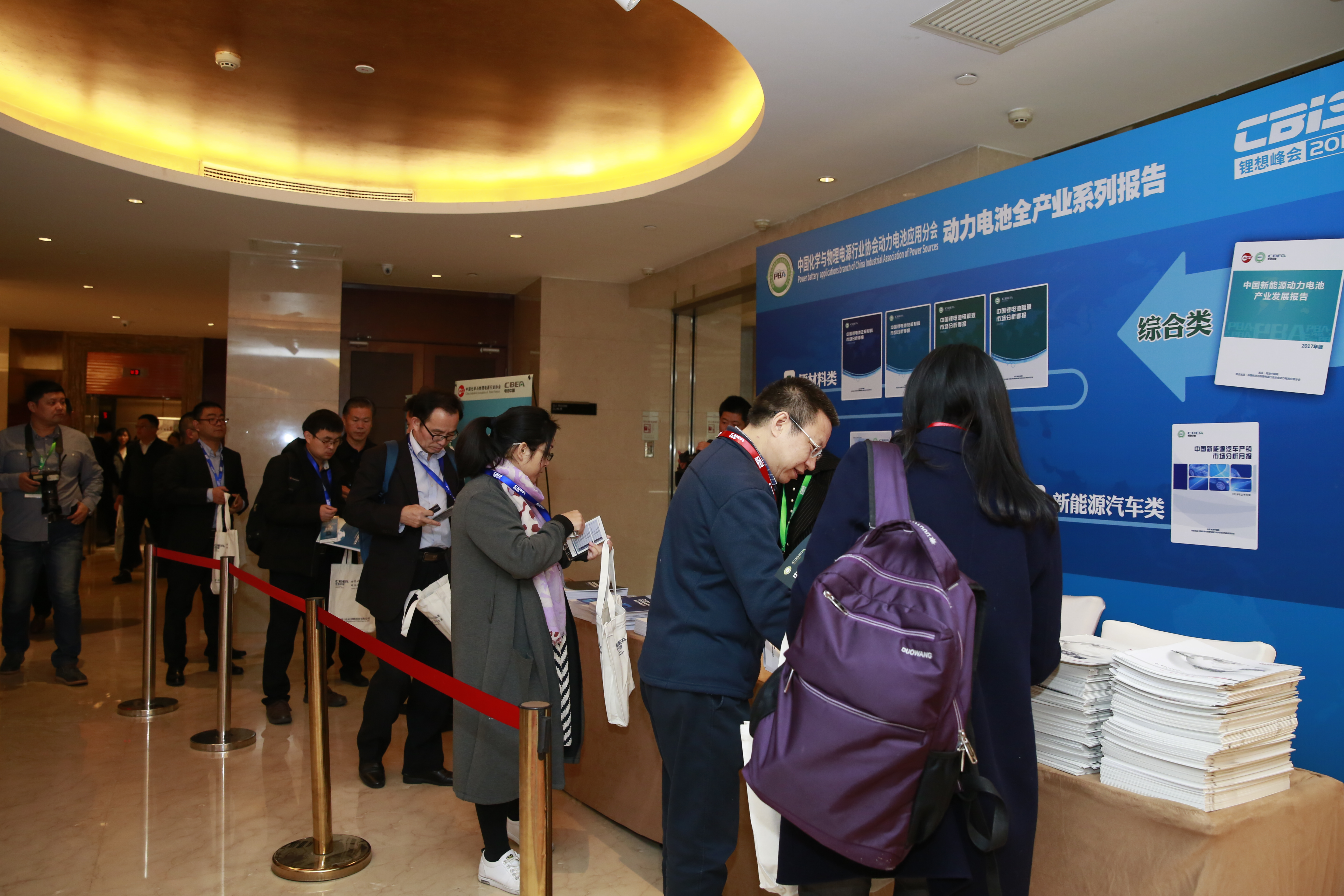 圖為參會嘉賓正在排隊領(lǐng)取動力電池應(yīng)用分會提供的行業(yè)研究報告